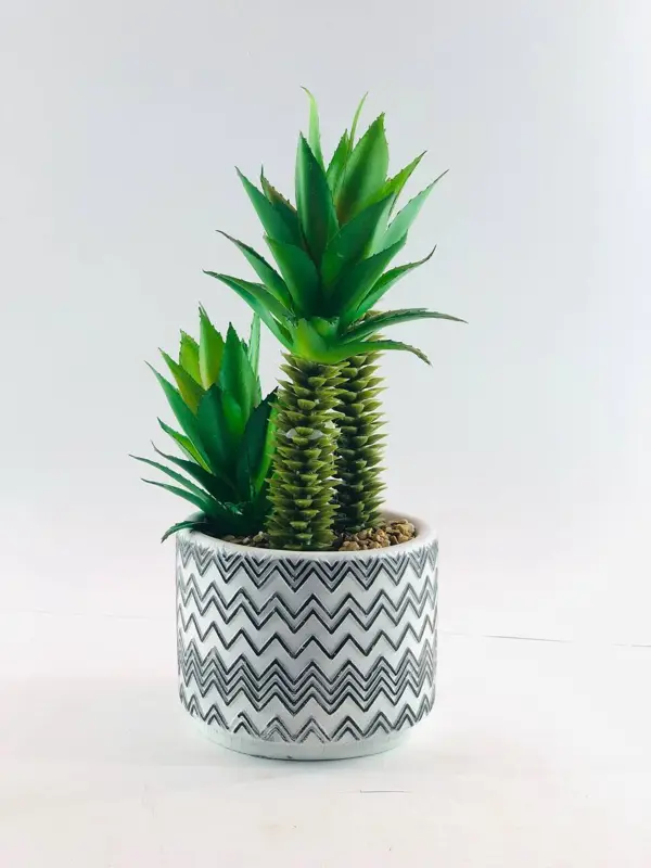 قطعة الديكور الخضراء في وعاء بلاستيكي أبيض بتصميم رخامي